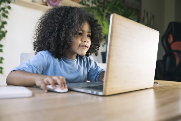little afro boy, does homework at home with computer, back to school, homeschooling